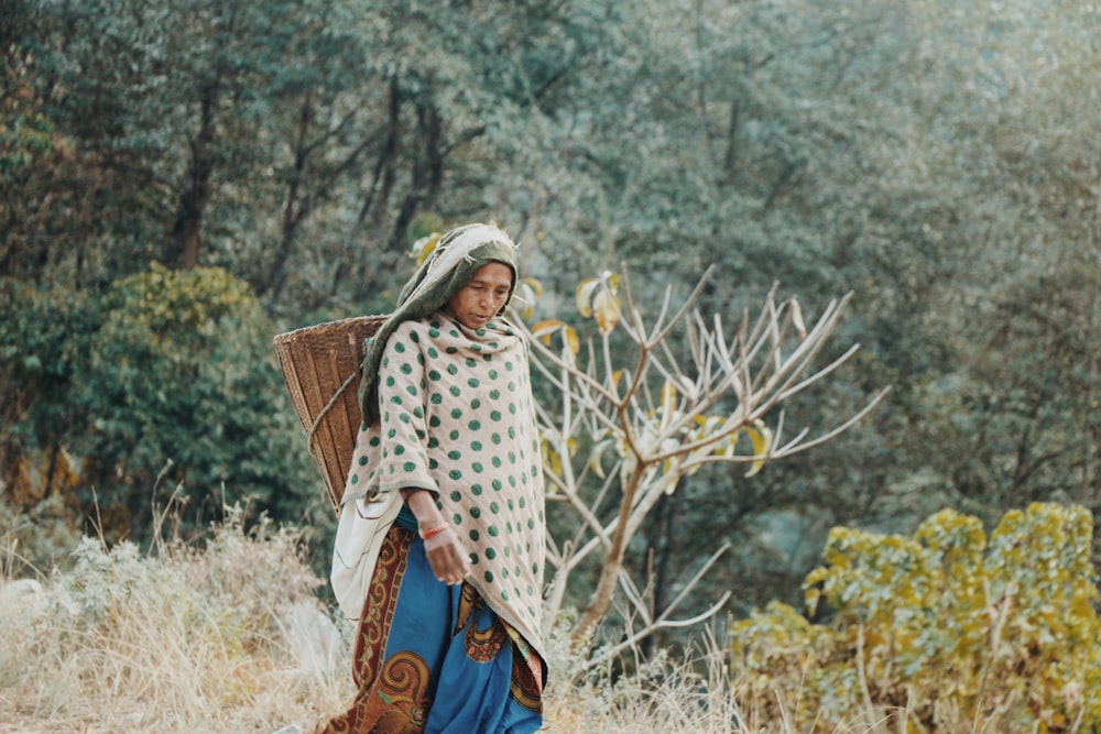 woman in white and black long sleeve shirt and blue skirt holding brown wooden basket