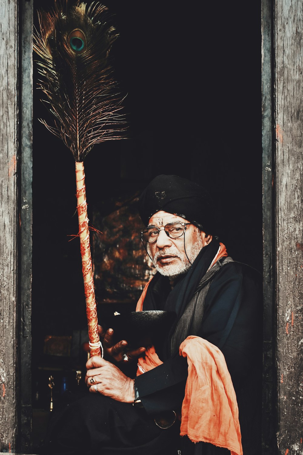 man in black coat holding stick