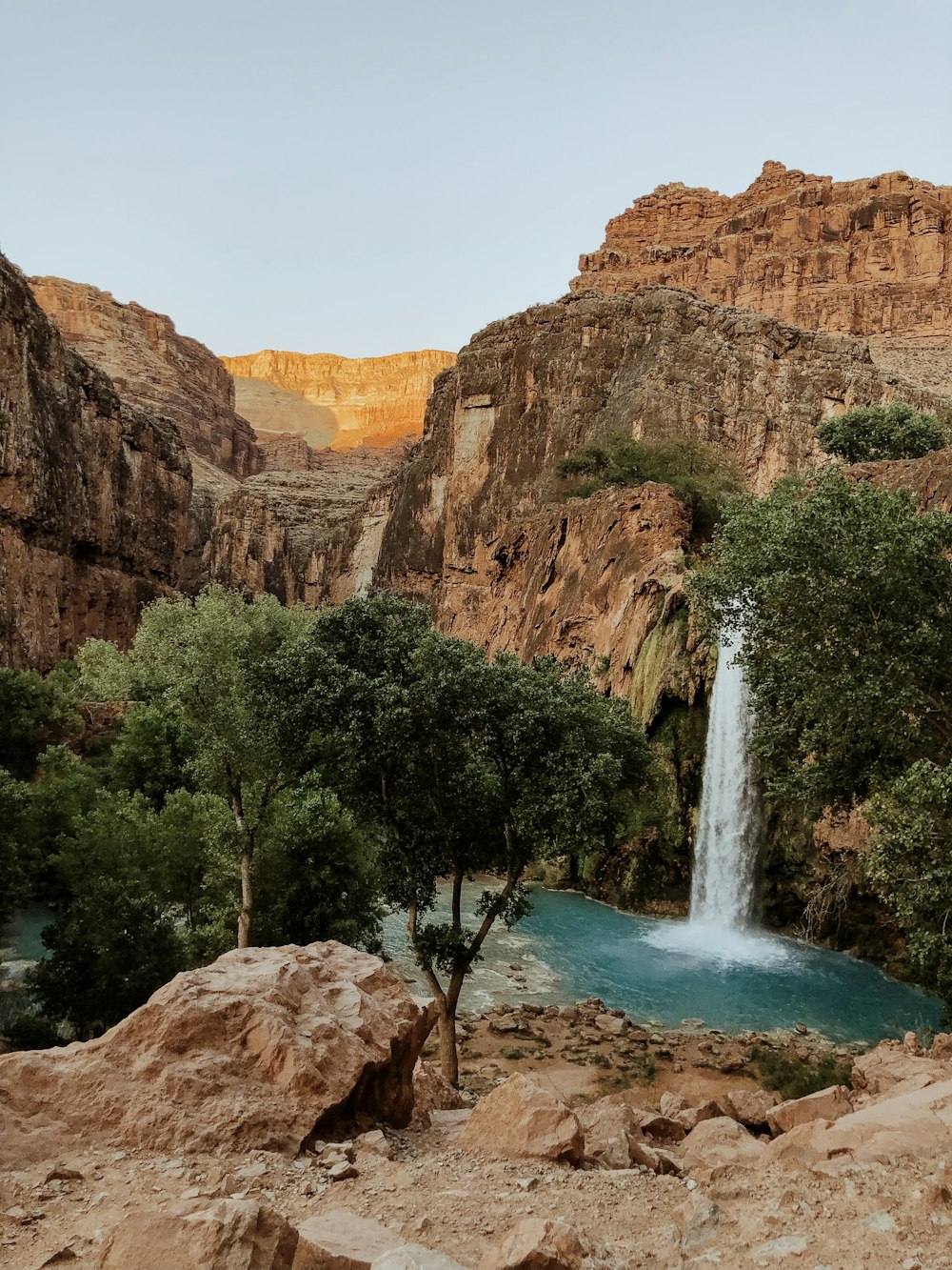 waterfalls in the middle of brown rocky mountains