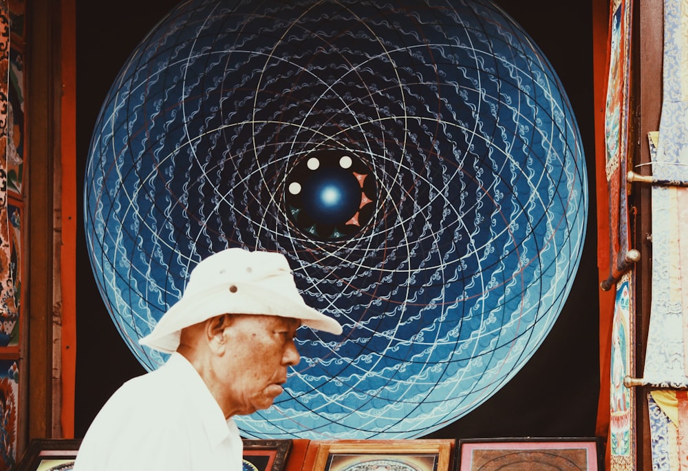 man in white hoodie standing near blue and white ball