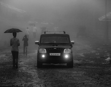 grayscale photo of black car on road