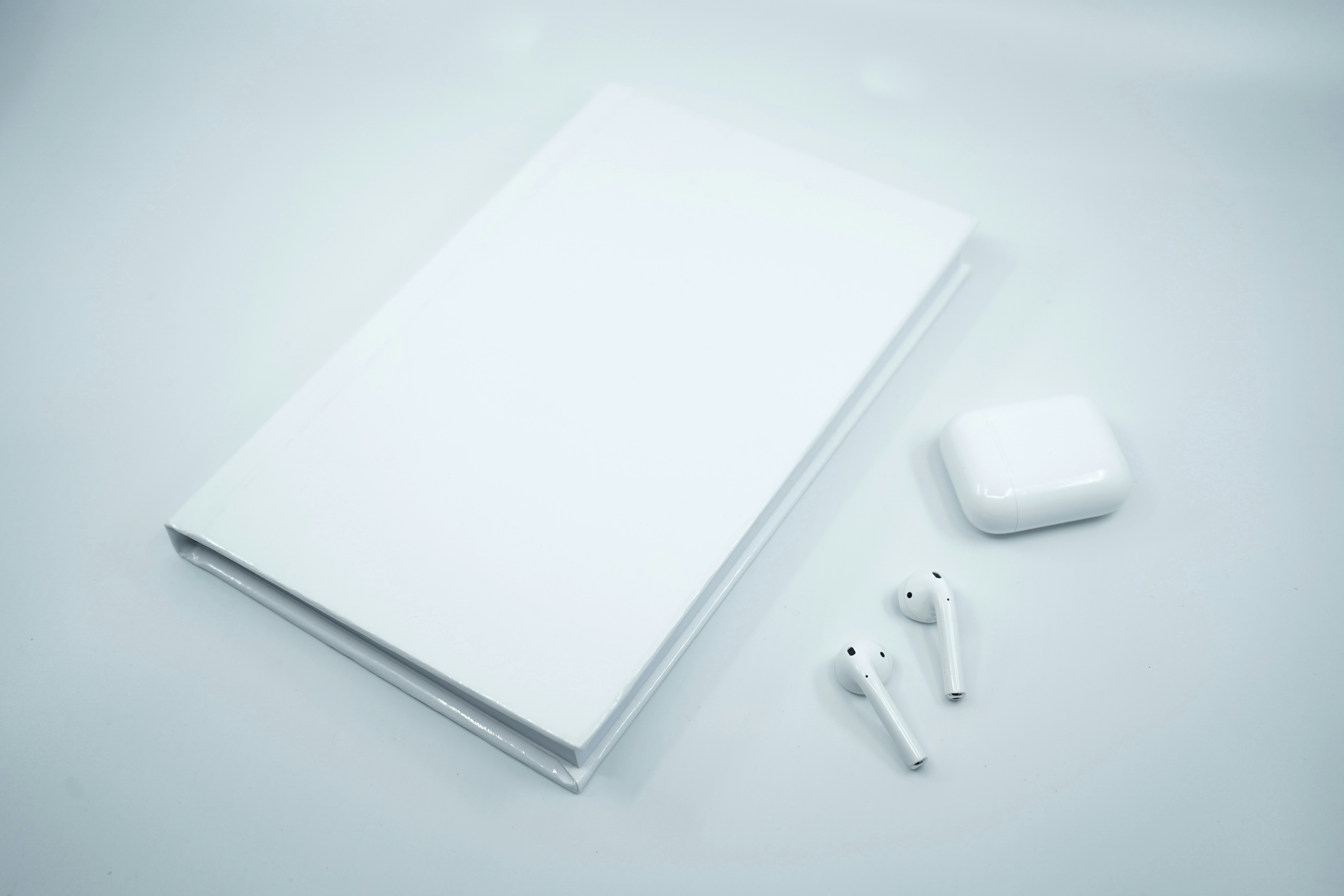white apple earpods on white surface