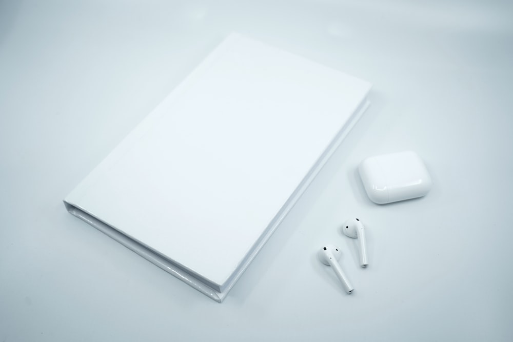 white apple earpods on white surface