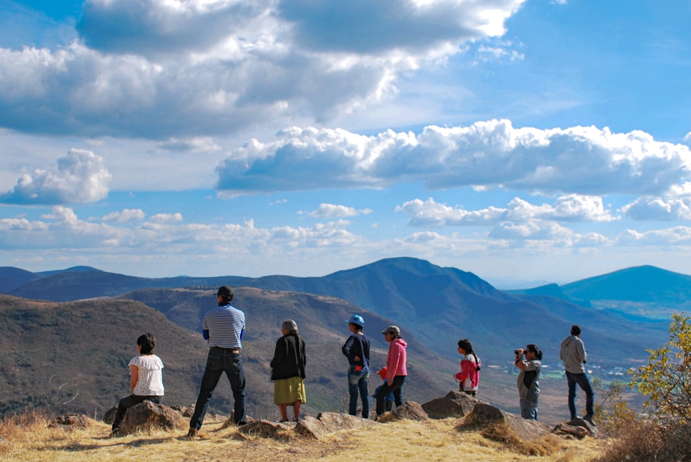group of people standing on brown rock mountain during daytime