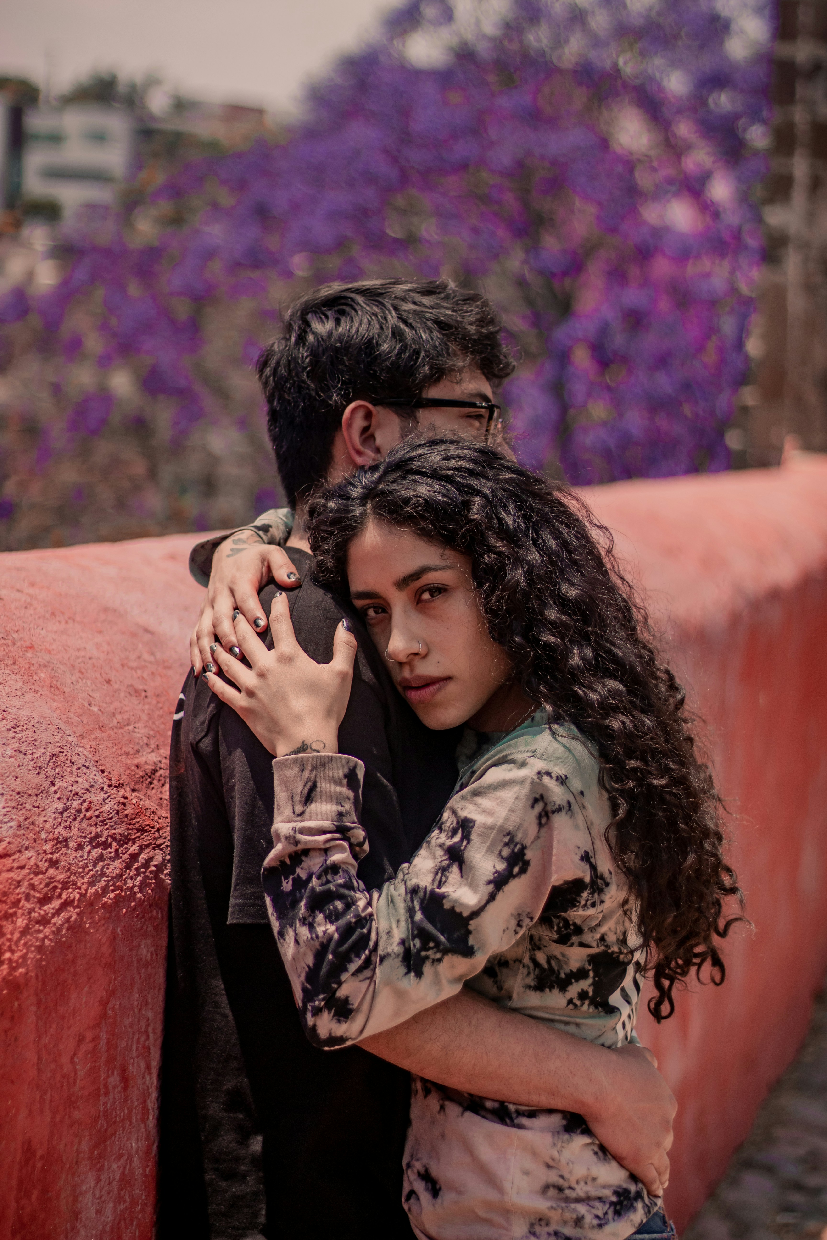 Frau in schwarz-weißem geblümtem Langarmhemd bedeckt ihr Gesicht mit ihren Haaren