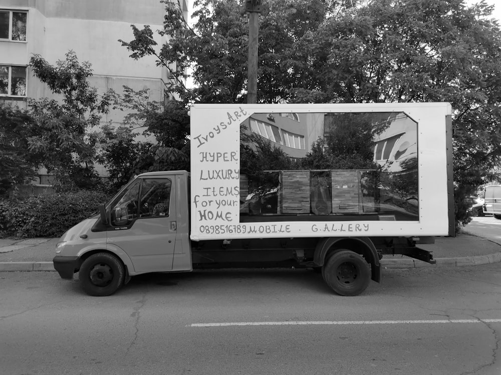 grayscale photo of van parked near trees