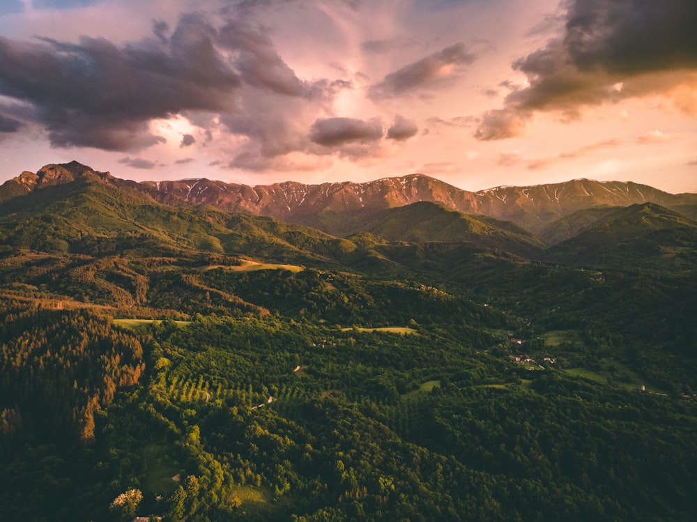 green and brown mountains under cloudy sky during daytime