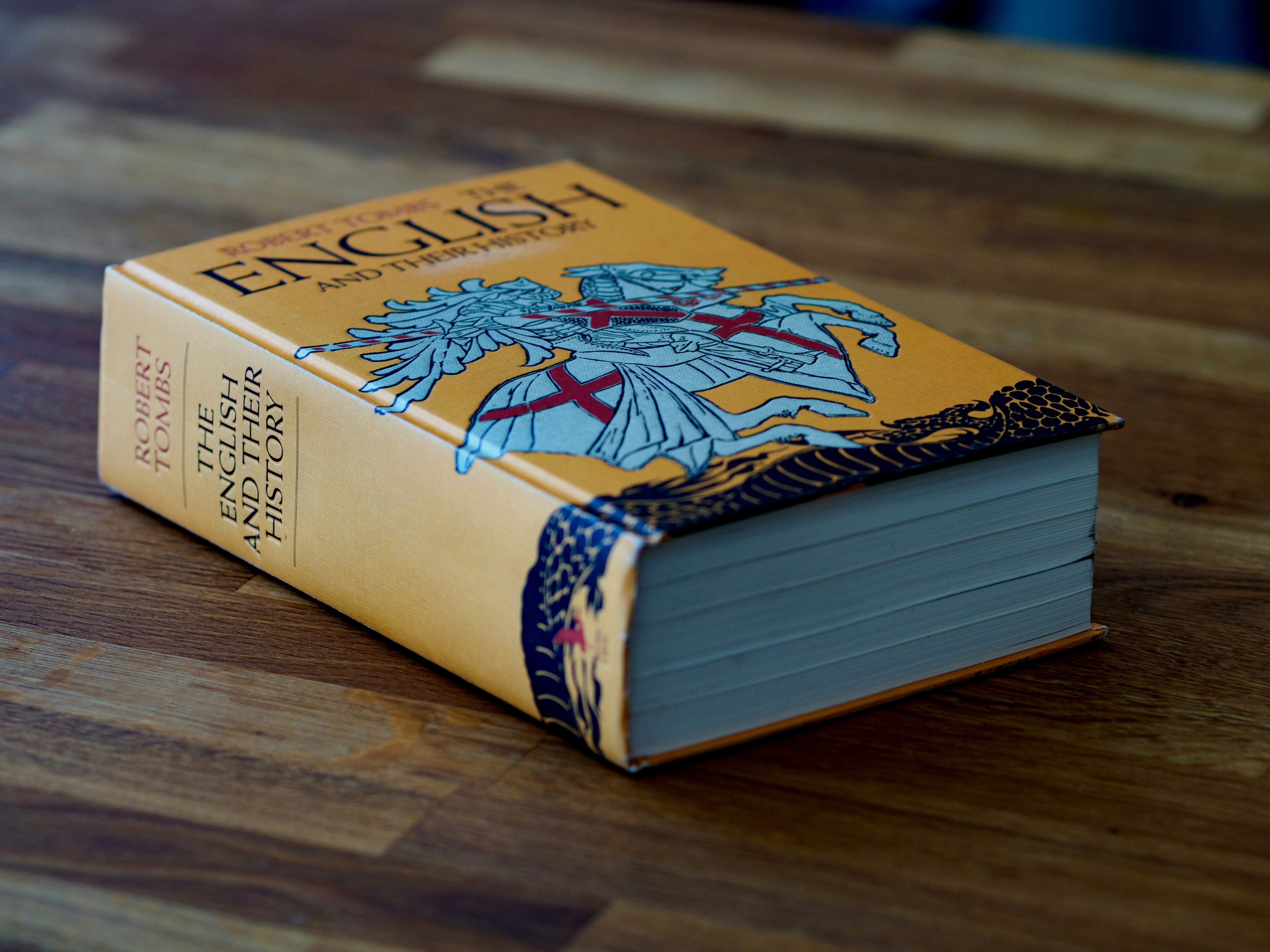 sebuah buku yang duduk di atas meja kayu