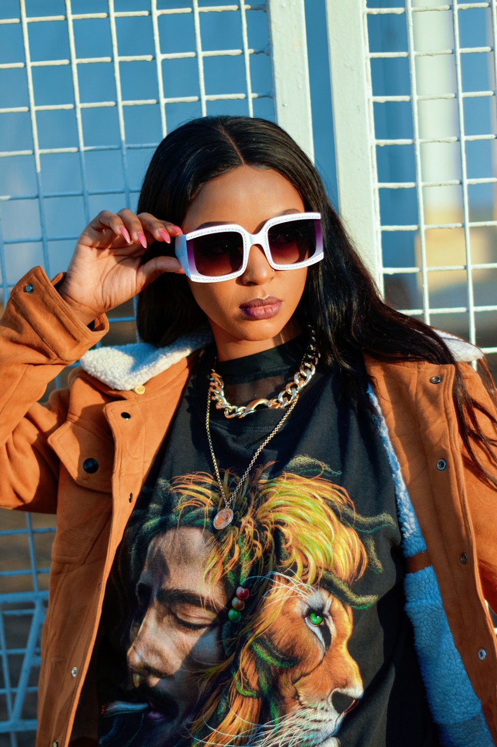 woman in brown coat wearing white framed sunglasses