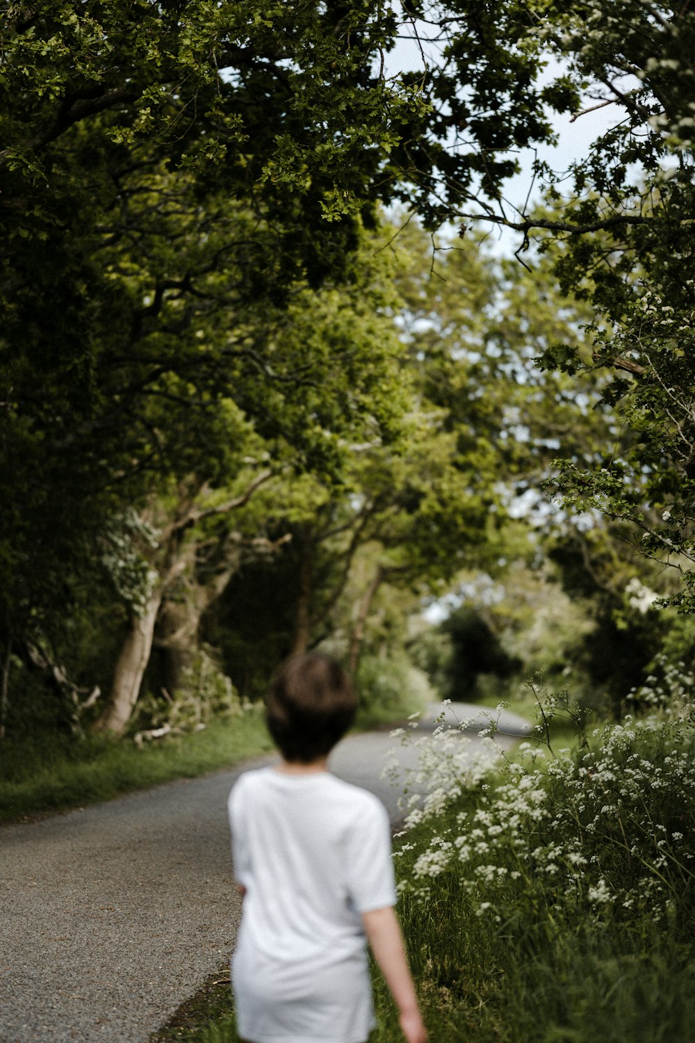 woman in white shirt walking on pathway during daytime