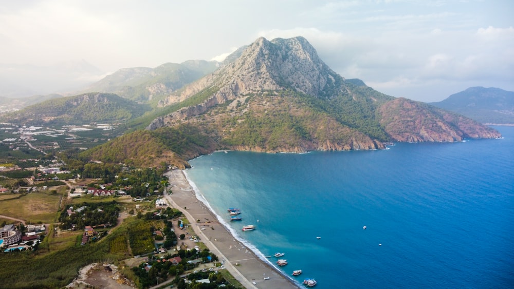 aerial view of green and brown mountain beside body of water during daytime