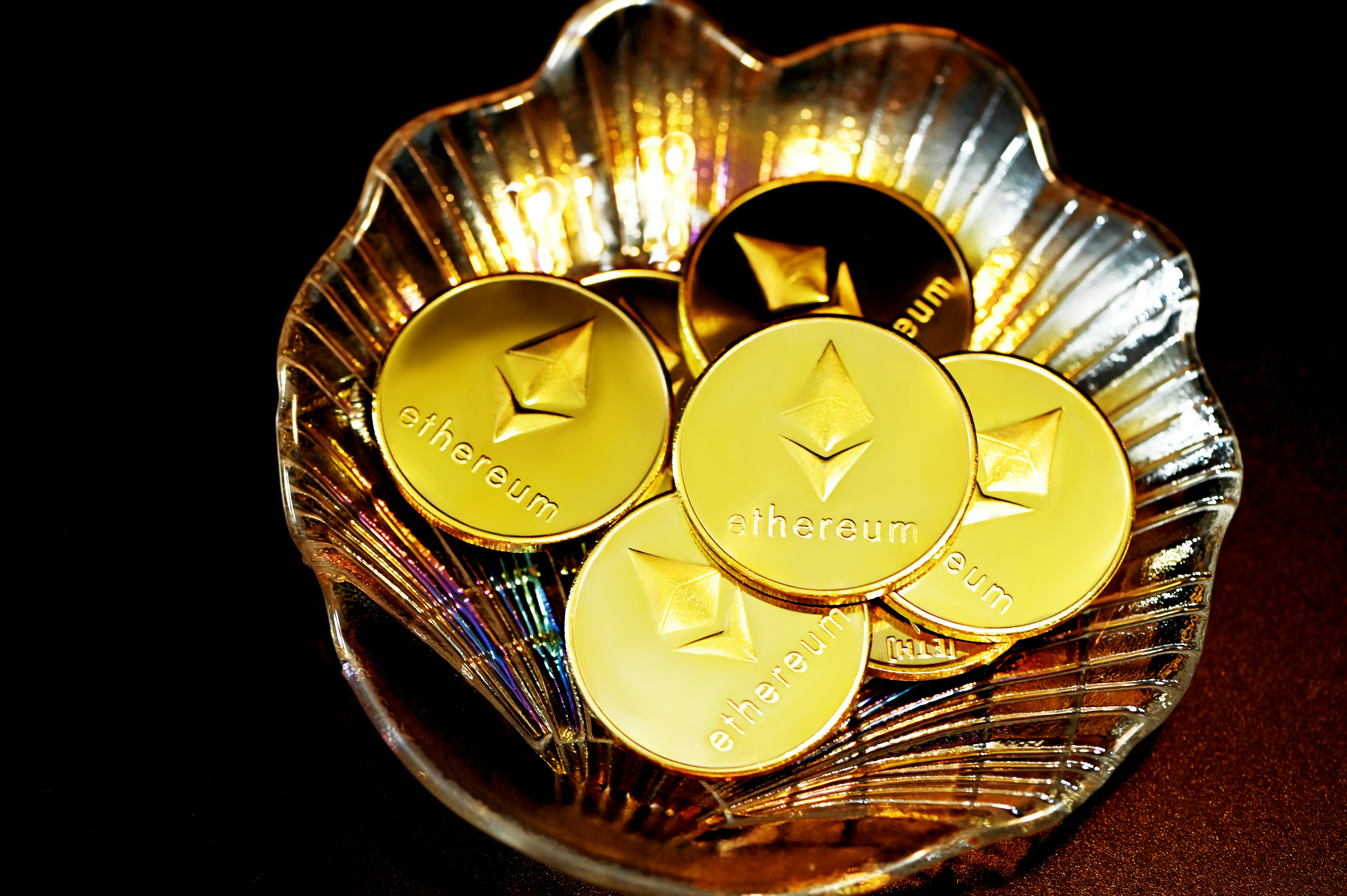 A pile of Ethereum coins in a seashell plate.