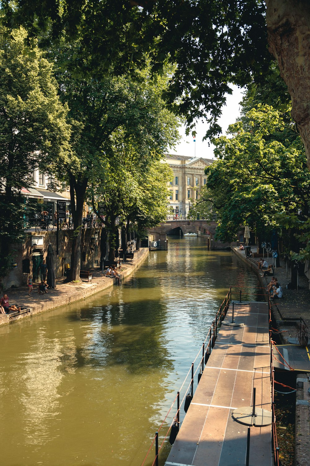 Persone che camminano sul marciapiede vicino al fiume durante il giorno