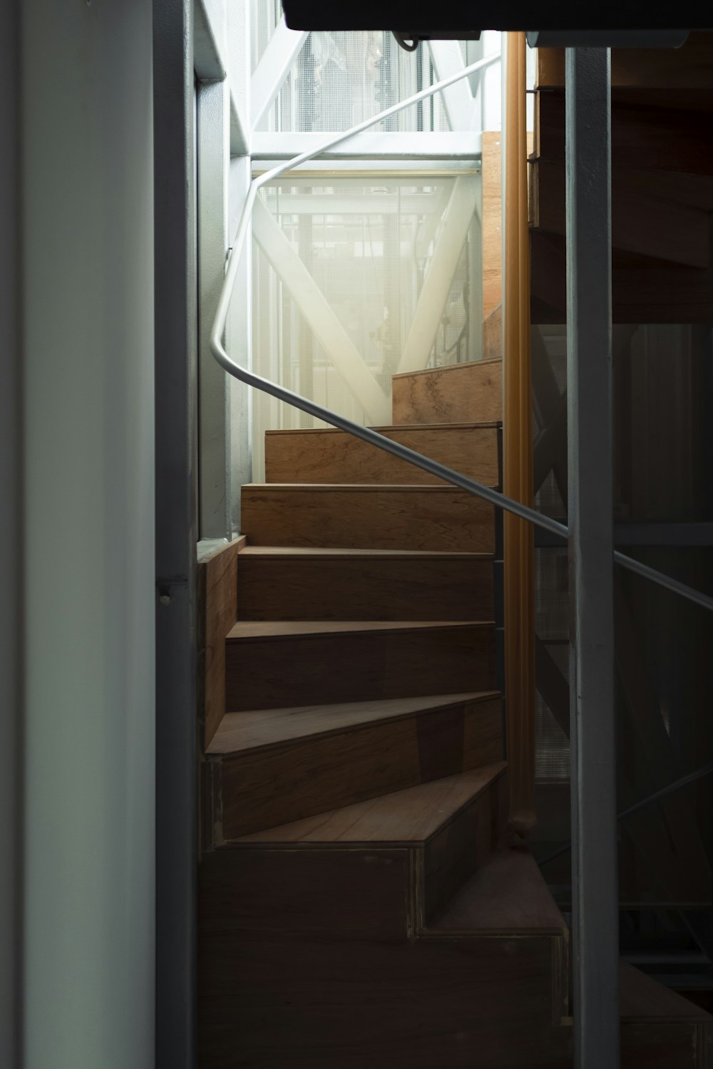 Escalera de madera marrón cerca de la ventana de vidrio