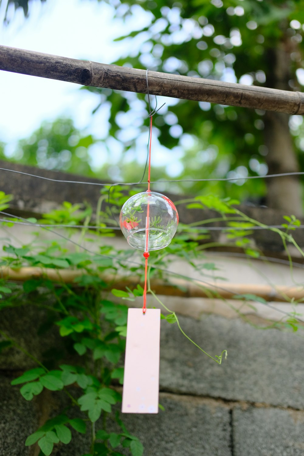 clear glass ball hanging on brown wooden stick during daytime