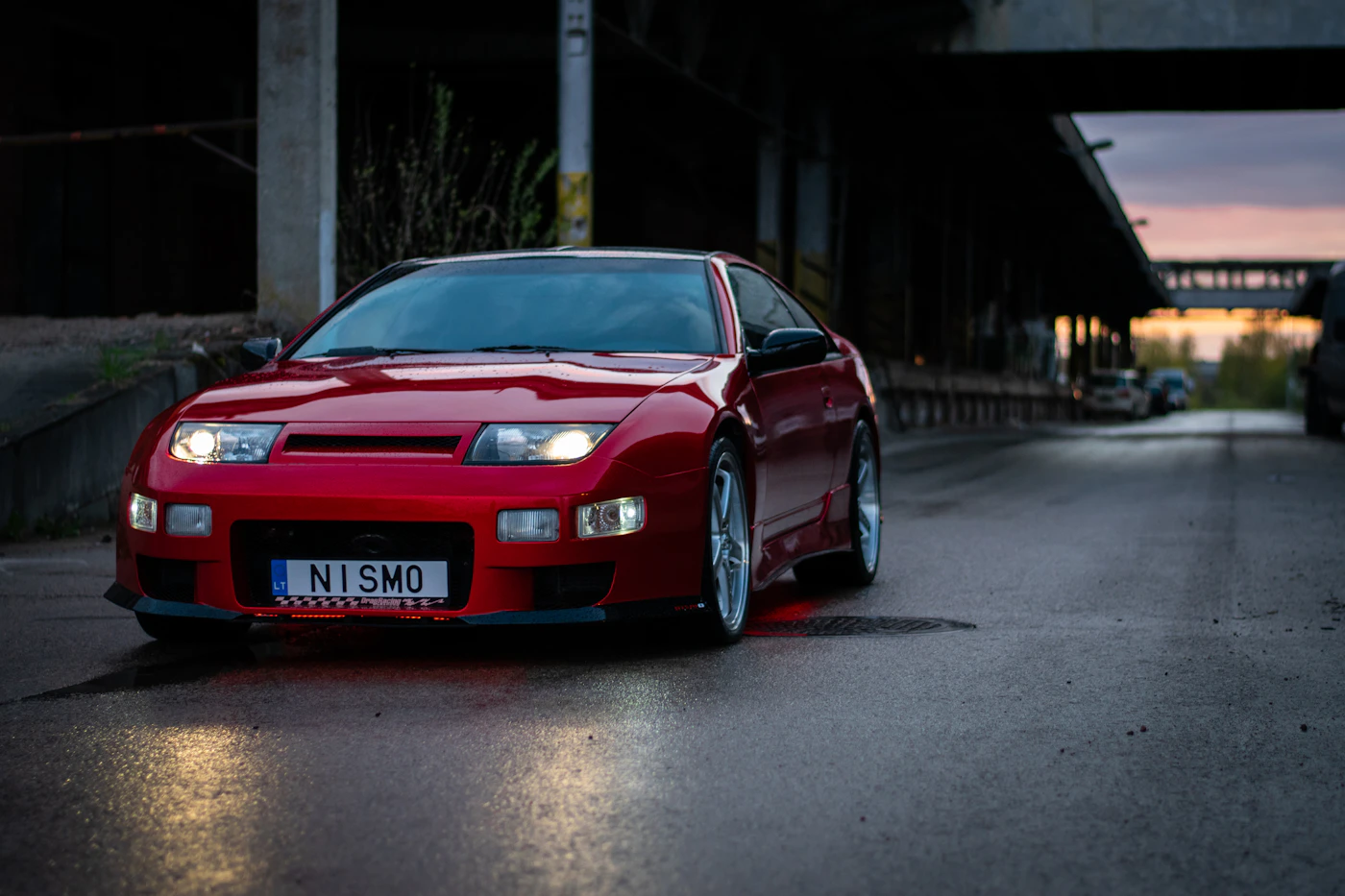 Red sports car on a road during daytime