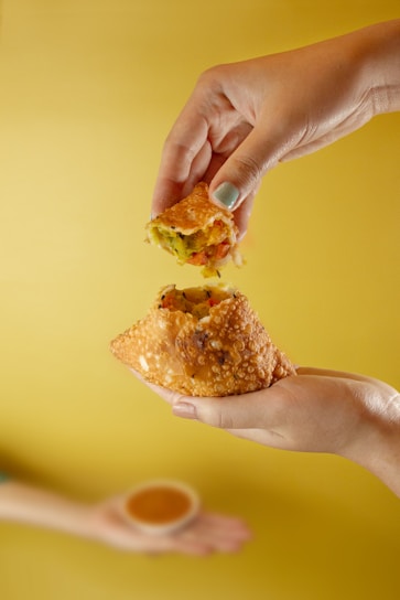 person holding brown bread with cheese