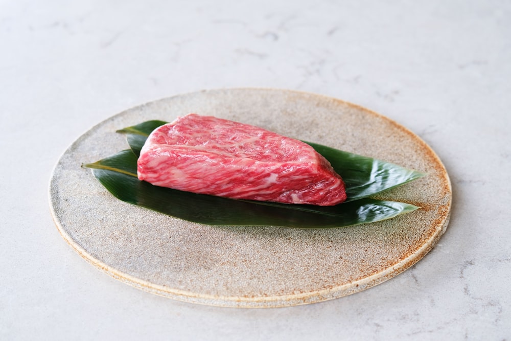 raw meat on white and green floral ceramic plate