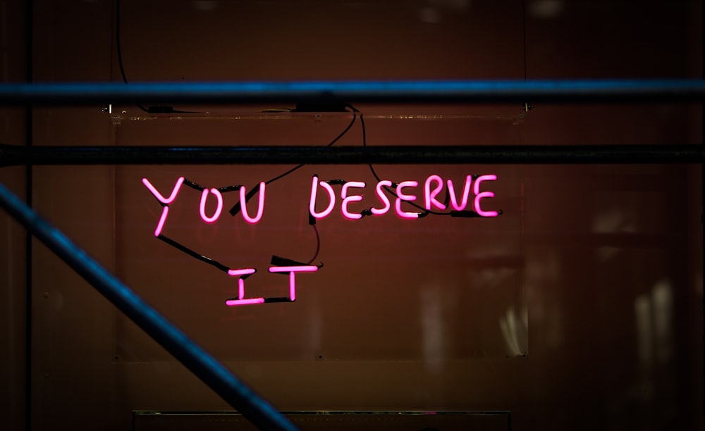 a neon sign that says you deserves it