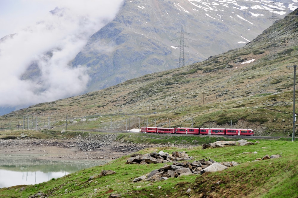 낮에는 산 근처의 철도에 빨간색과 흰색 기차