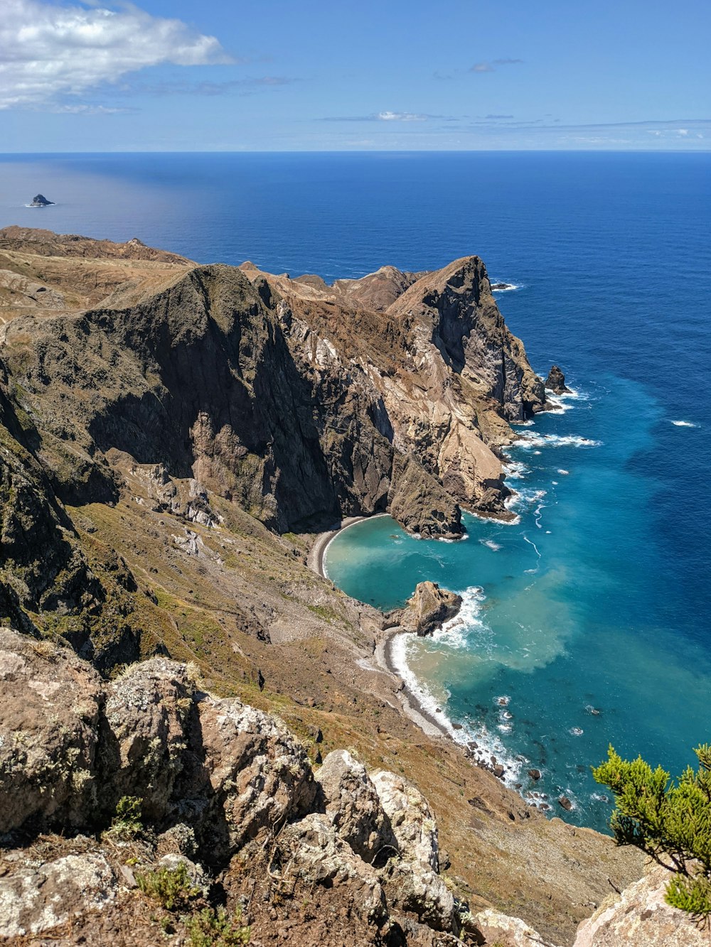 aerial view of green and brown mountain beside blue sea during daytime