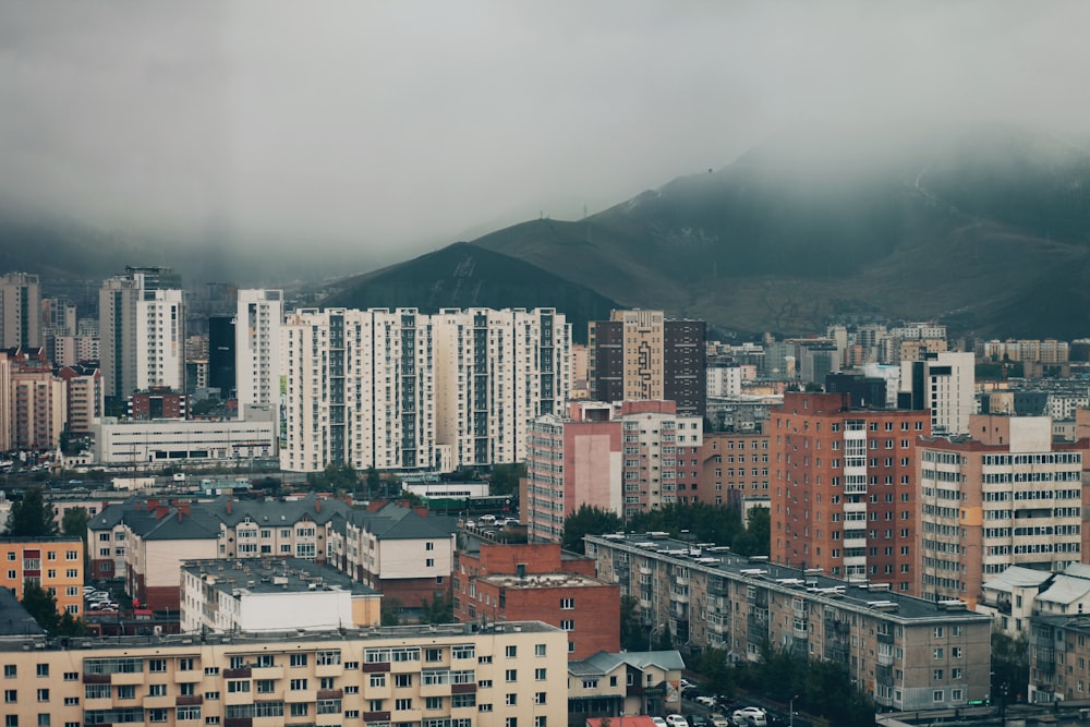 high rise buildings near mountain during daytime