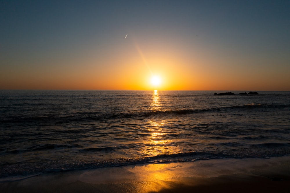 sea waves crashing on shore during sunset