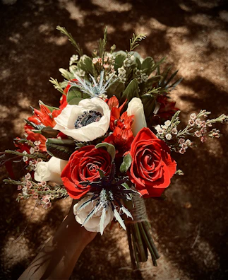 A chic flower arrangement combining red tulips and roses, shot with sharp shadows.