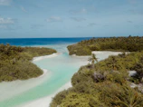 A serene lagoon with seven distinct shades of blue under a bright sky.