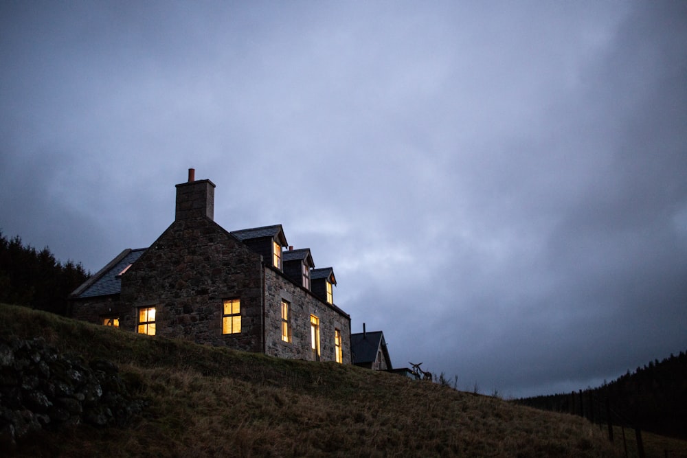 brown brick house on hill under cloudy sky