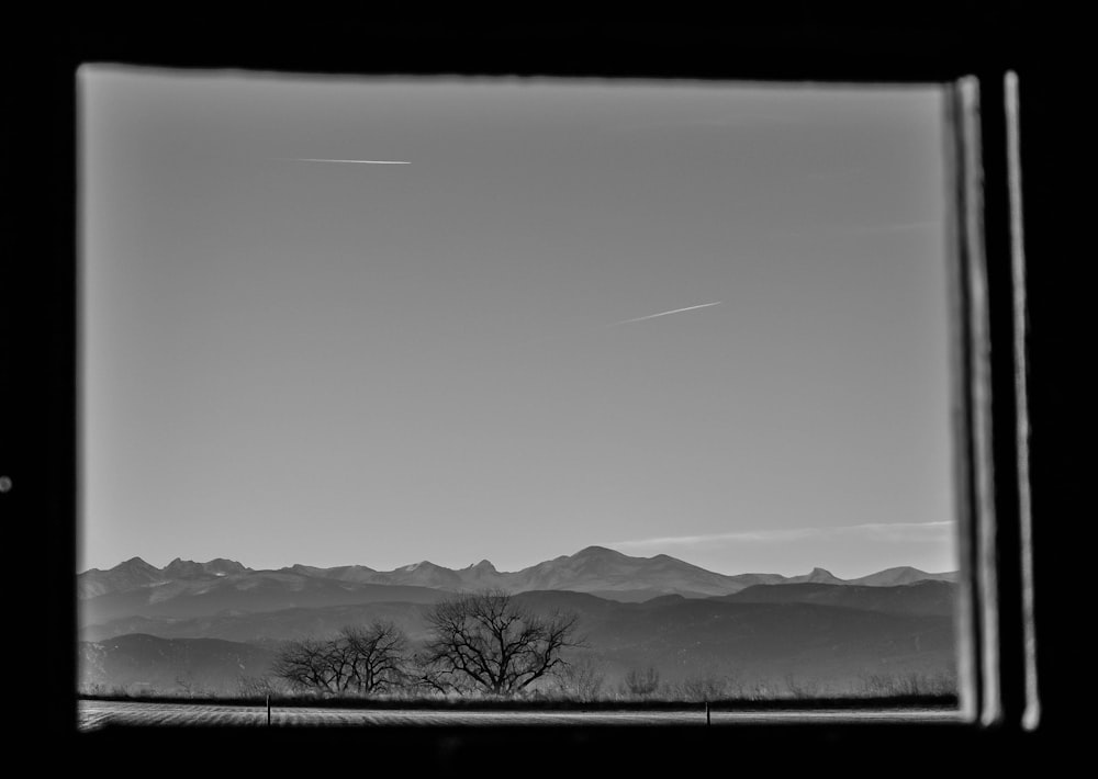 grayscale photo of mountains and trees