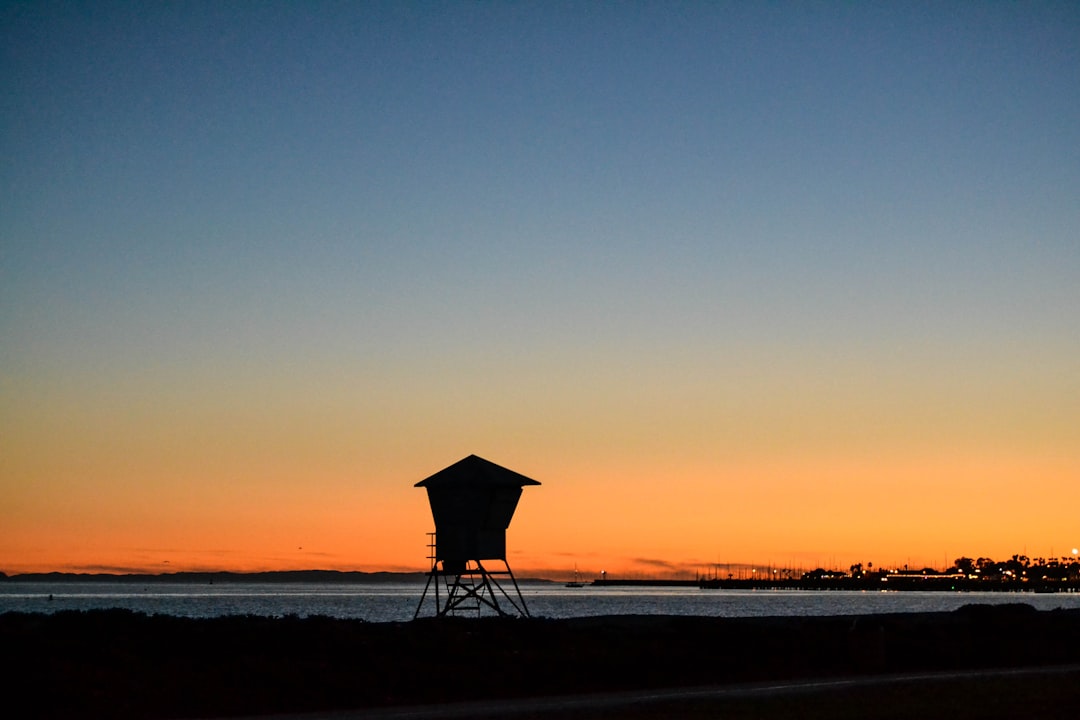 silhouette of beach umbrella during sunset