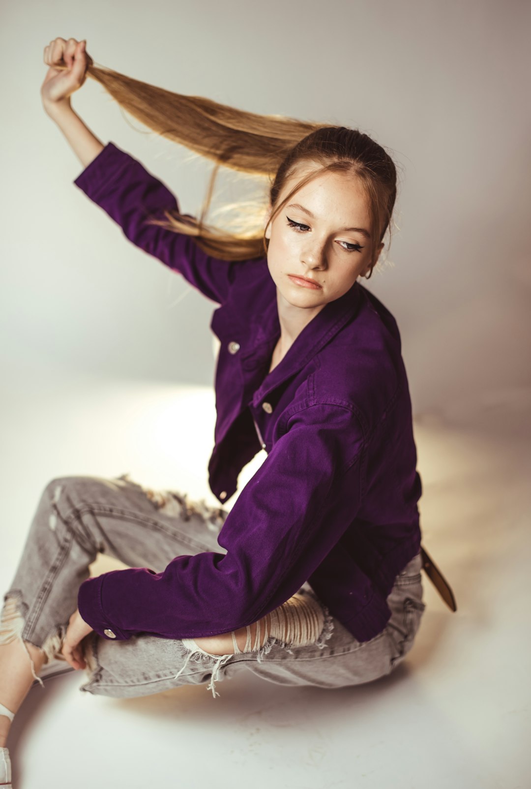 woman in black jacket and gray pants sitting on brown wooden chair