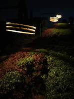 Solar garden lights from the G series enhancing a lush park pathway under the night sky.