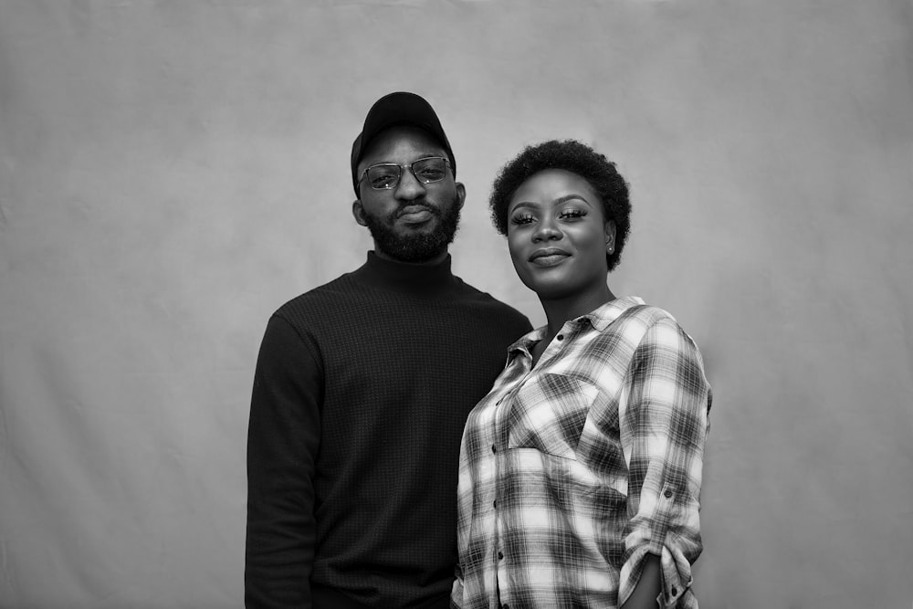 man in black sweater beside woman in plaid dress shirt