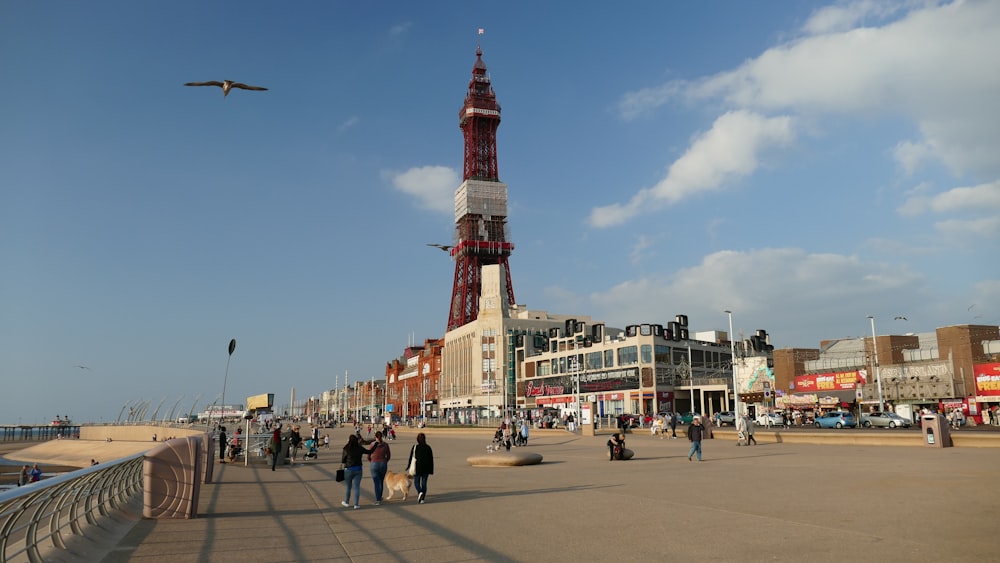 people walking on street near red and white tower during daytime