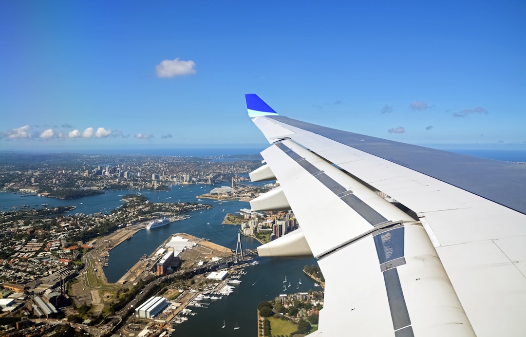 white airplane wing over city during daytime