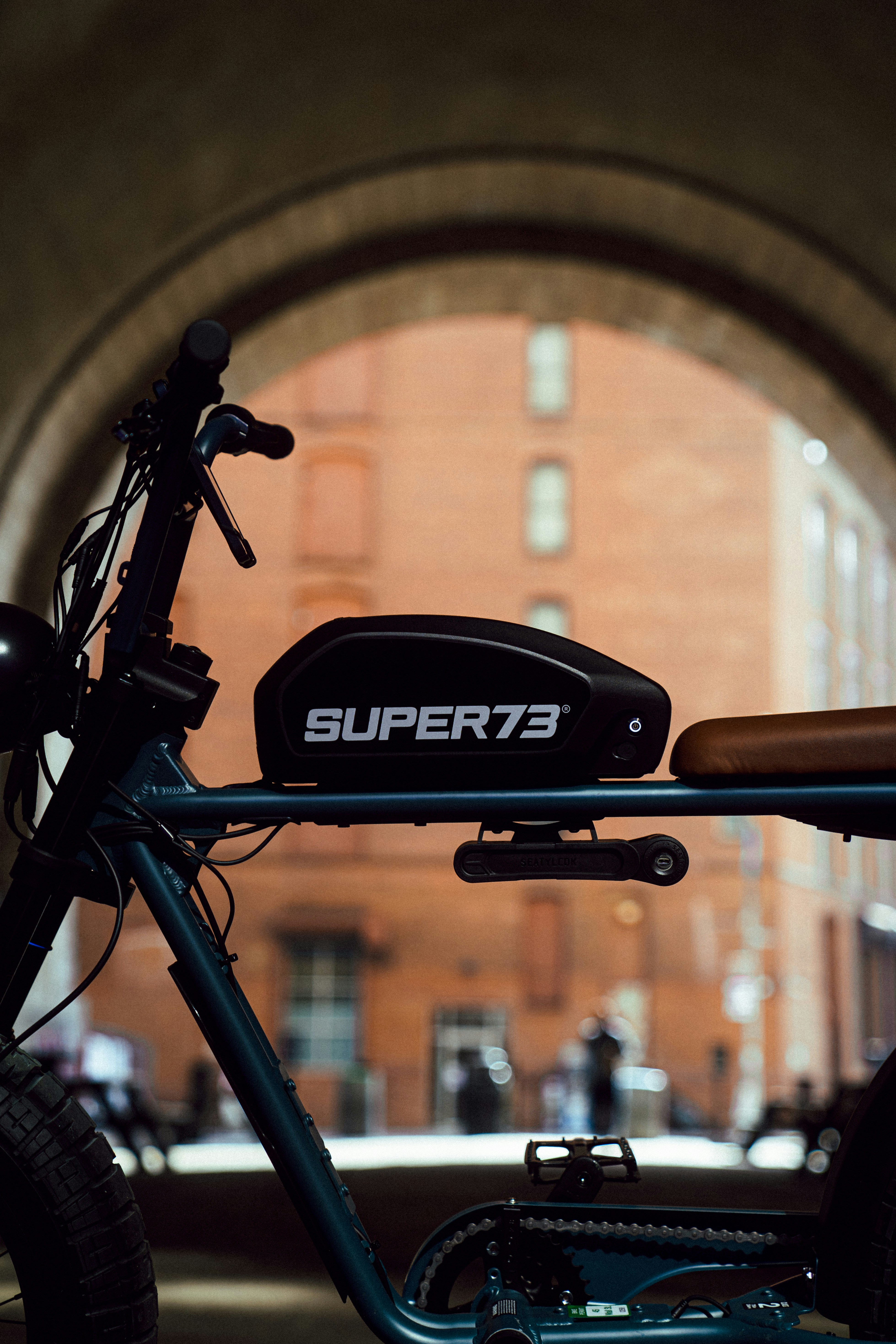 black and gray bicycle in front of brown brick wall