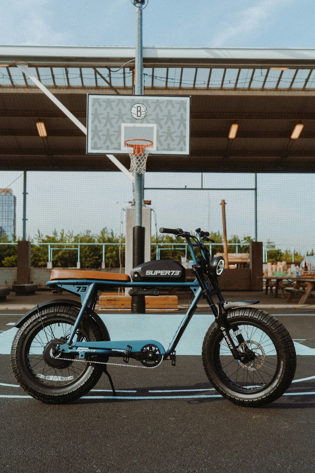 blue and black motorcycle parked near brown wooden post