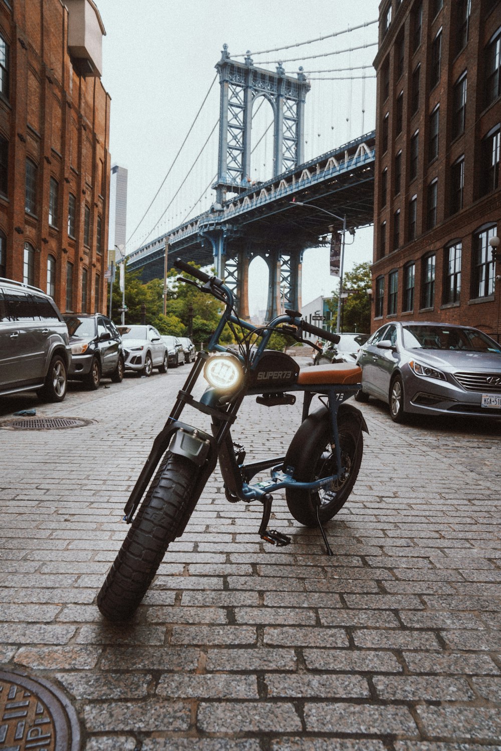 black motorcycle parked beside black car during daytime