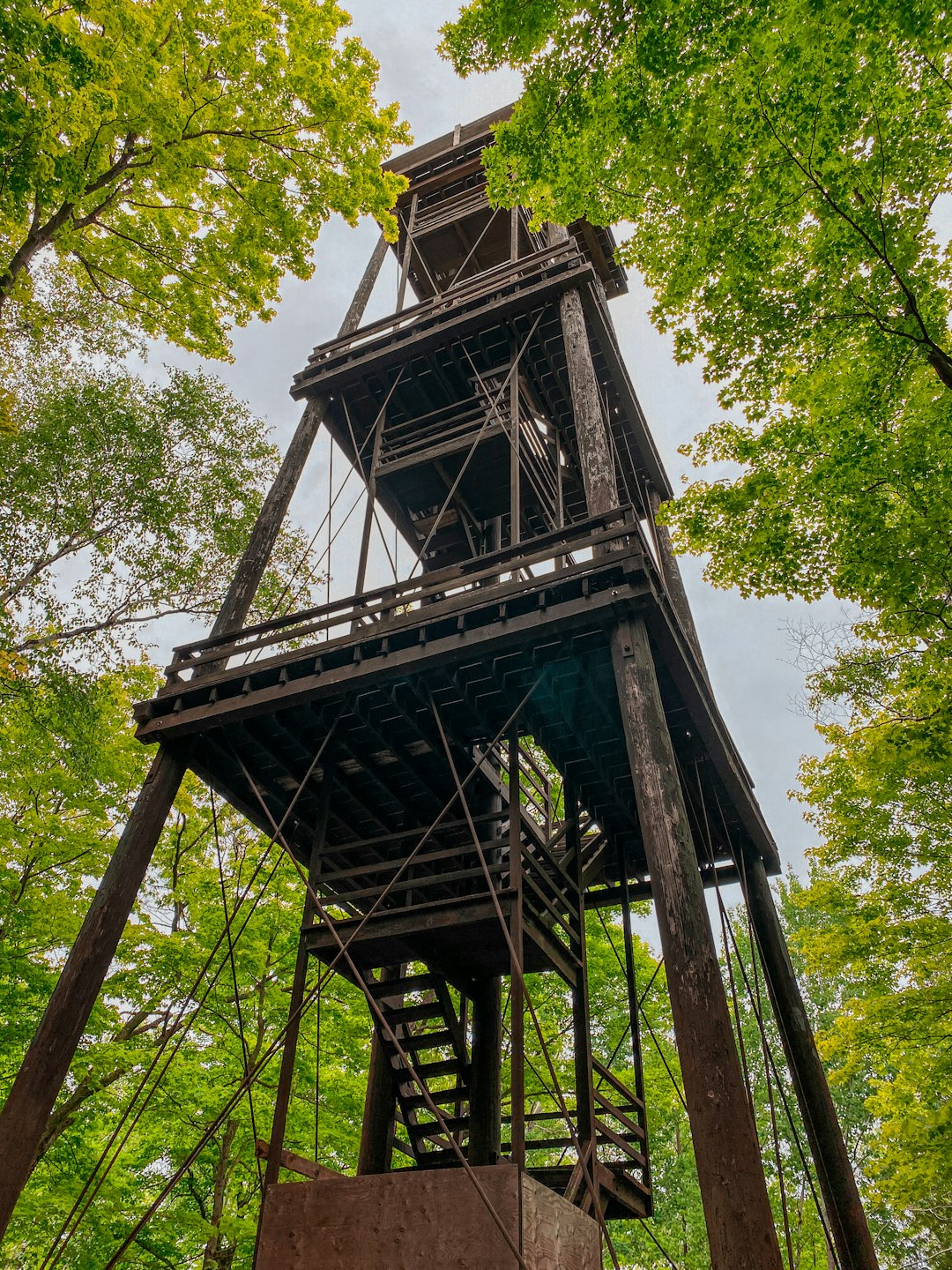 brown wooden tower surrounded by green trees during daytime