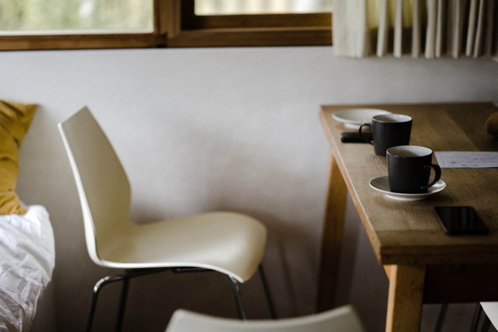 weiß-schwarzer Stuhl neben braunem Holztisch