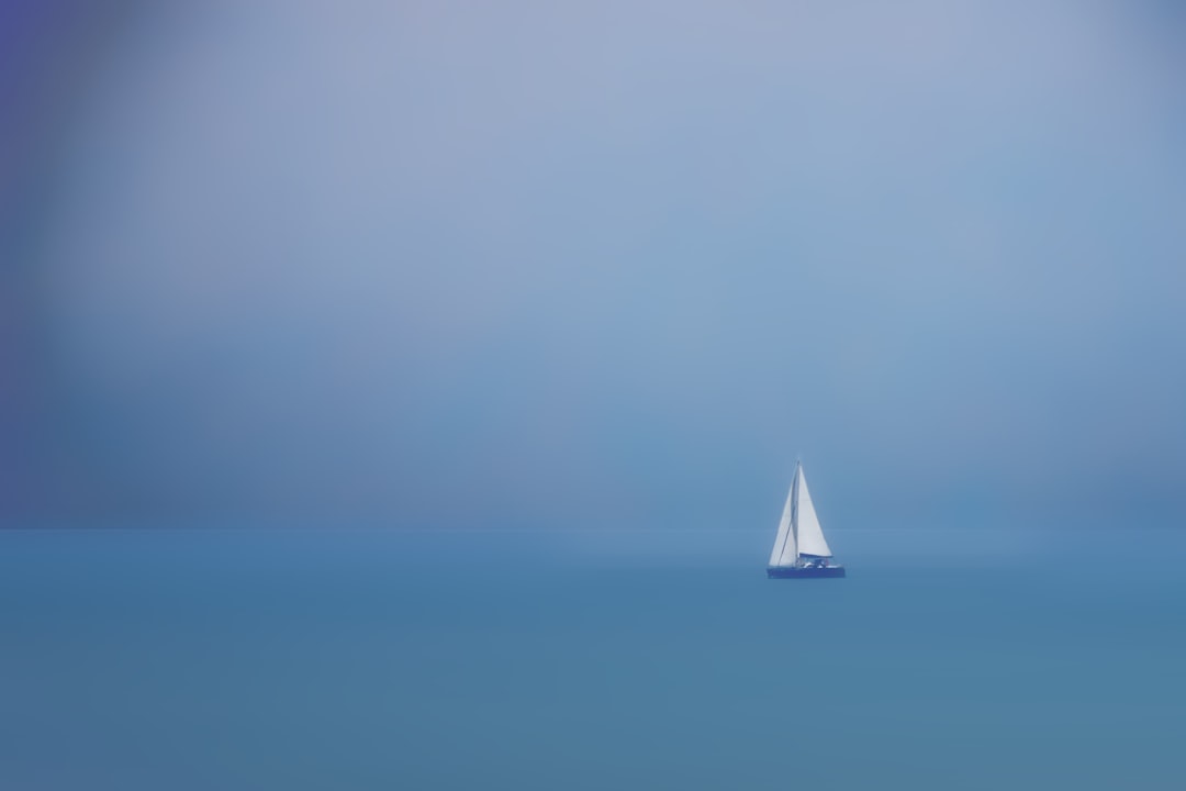 white sailboat on sea under blue sky during daytime