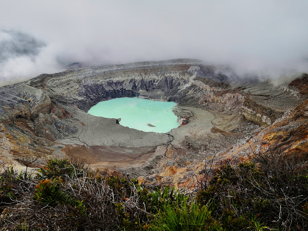 Formation rocheuse brune et grise près de la mer bleue sous des nuages blancs pendant la journée