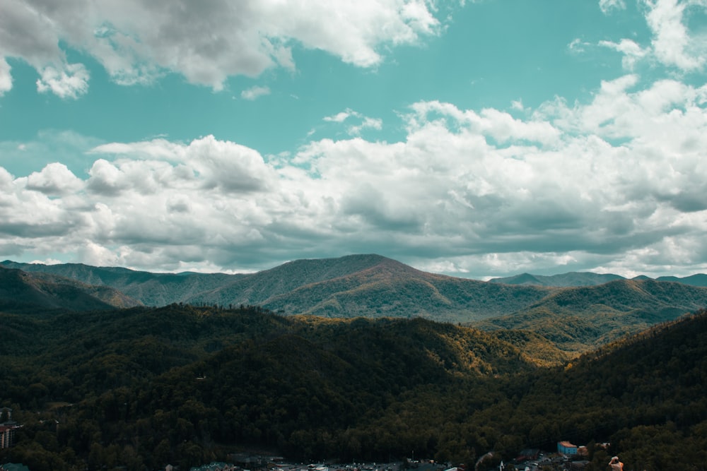 green and brown mountains under white clouds and blue sky during daytime