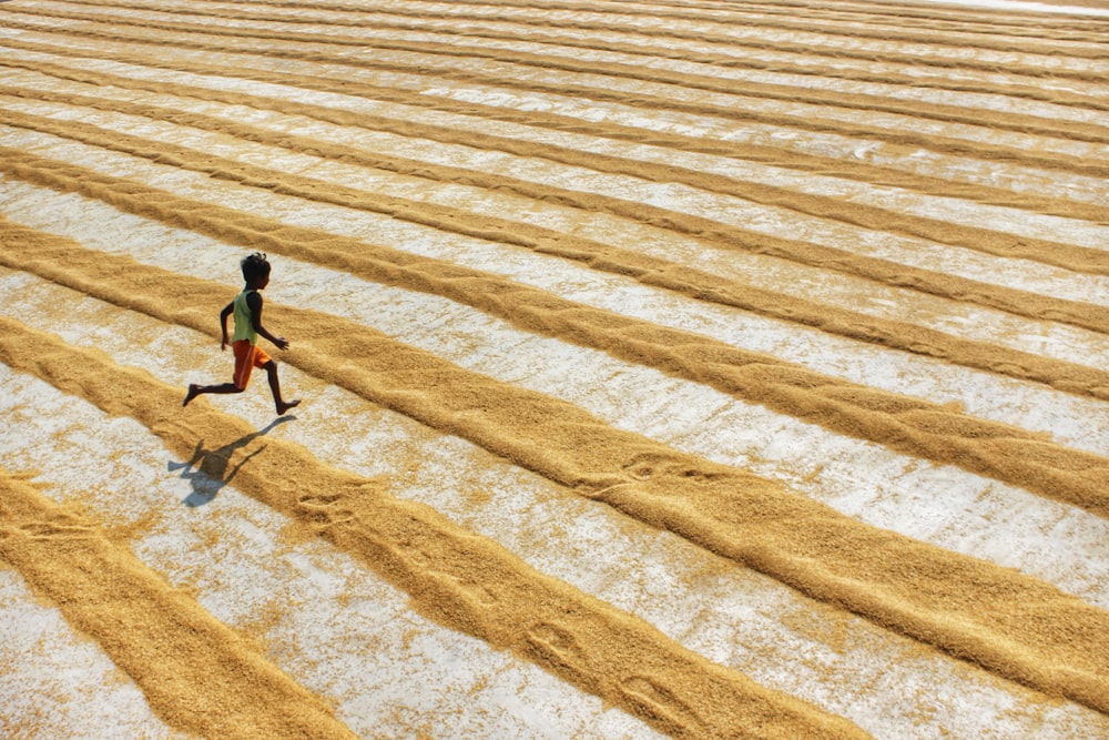 man in black shirt walking on brown sand during daytime