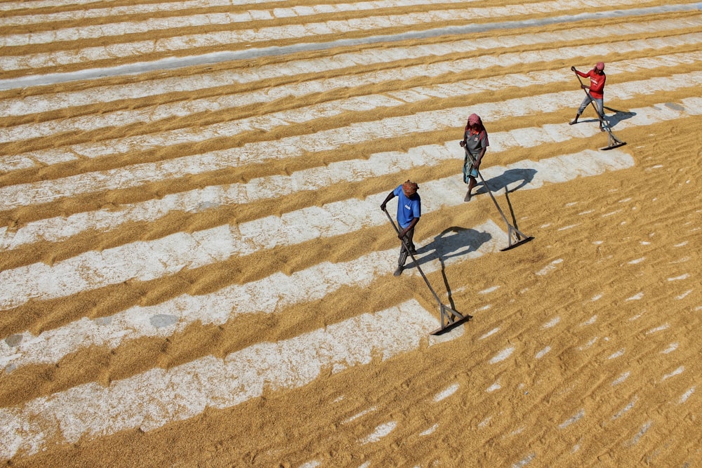 man in blue jacket walking on brown sand during daytime