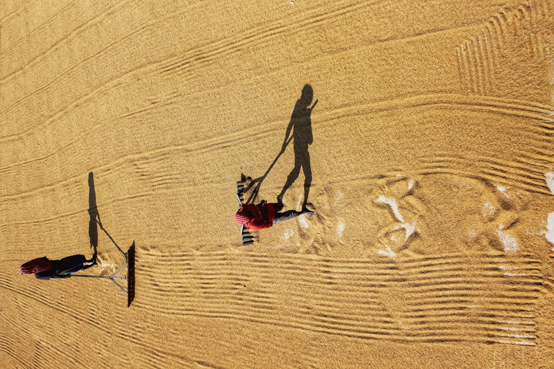 person in red shirt walking on sand