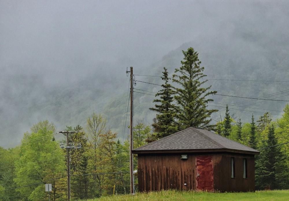 brown wooden house near green trees under white sky during daytime