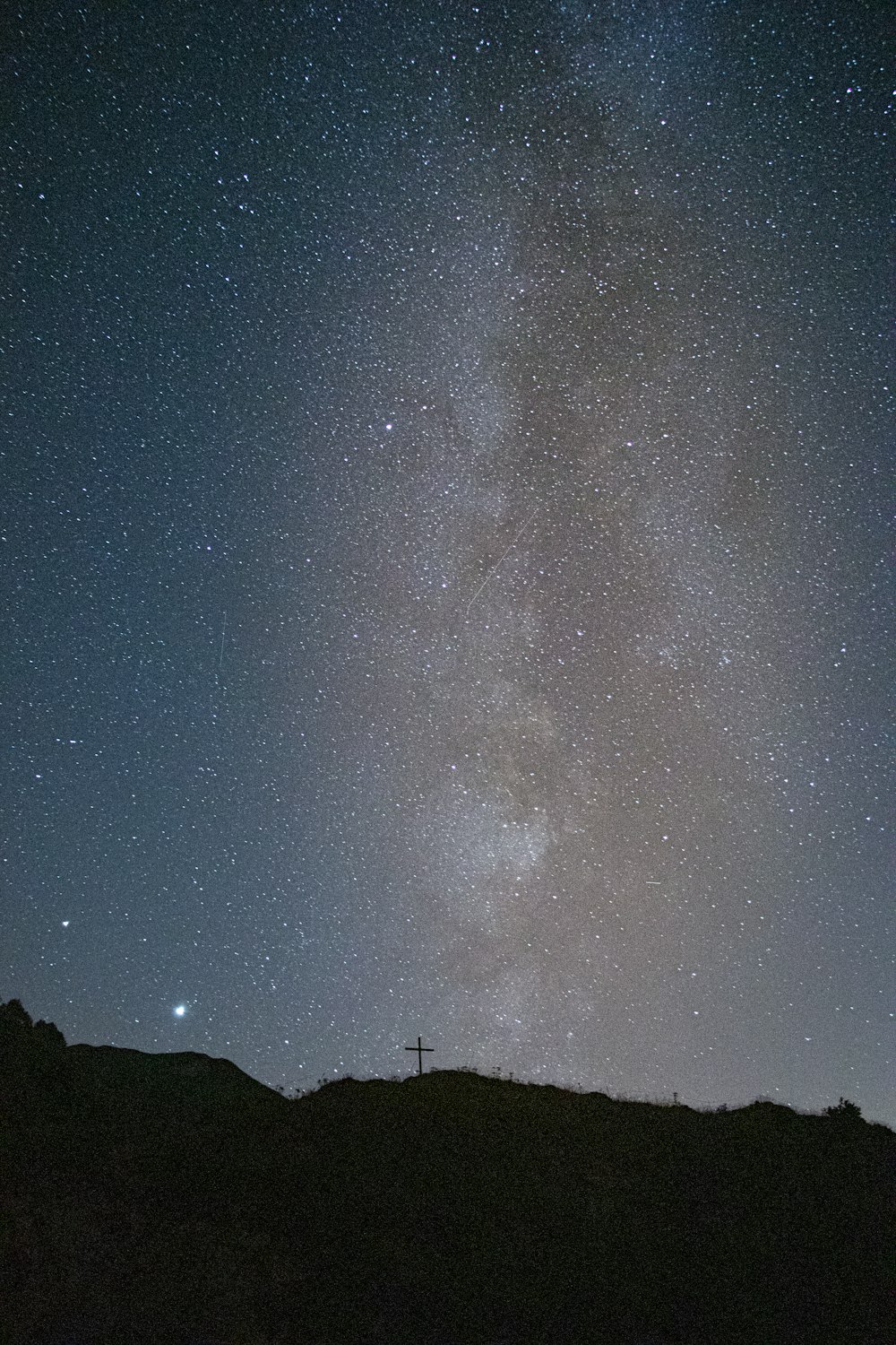 silhouette of mountain under starry night